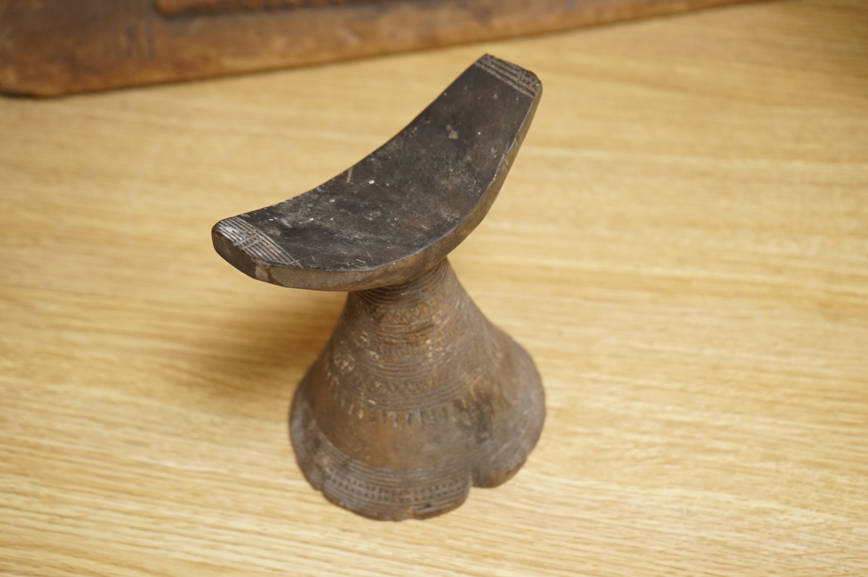 An Ashanti carved wood stool together with a similar headrest, tallest 41cm